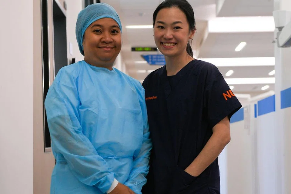 GEMBIRA BERTUGAS: Cik Julia Tubari (kiri), pembantu pembedahan gigi di Jabatan Pergigian Hospital Universiti Nasional (NUH), menganggap hubungan yang terjalin antara pesakit dengan doktor seperti Dr Tan Mei Na (kanan), pendaftar Jabatan Pergigian NUH, menandakan kepercayaan yang membuatnya berasa gembira dan menjadi dorongan kepadanya semasa bertugas. - Foto BM oleh SAHIBA CHAWDHARY