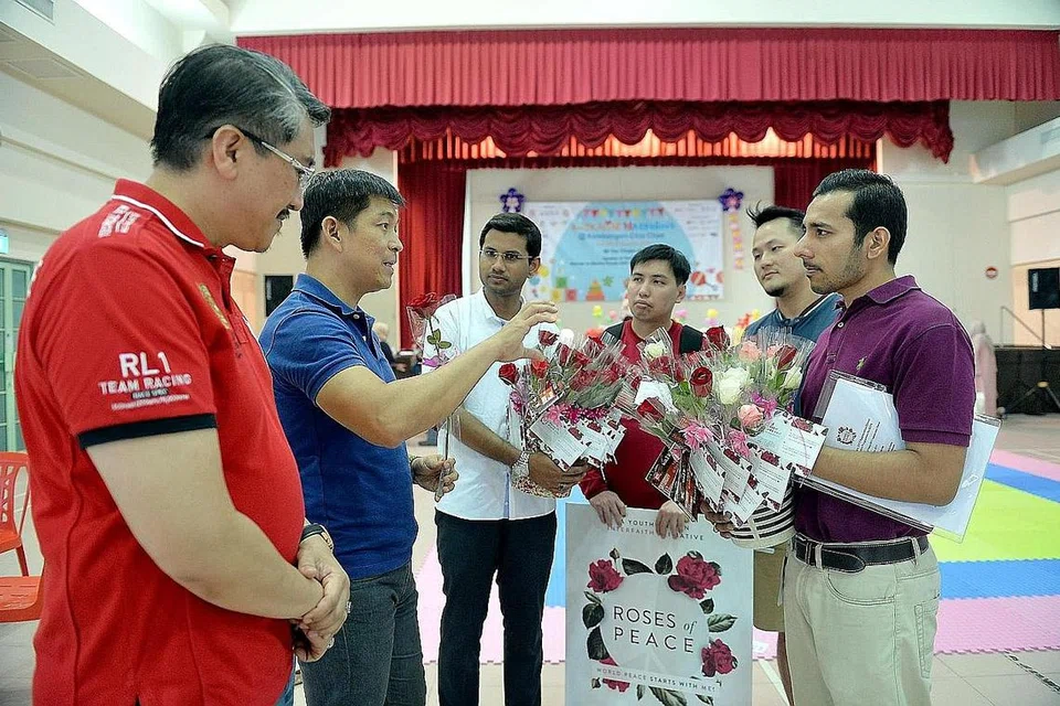SEBAR MESEJ KEHARMONIAN: Encik Mohamed Irshad (tiga dari kiri, berbaju putih) mengasaskan 'Roses of Peace' (ROP) pada 2012 dengan tujuan memperkukuh kesepaduan sosial dalam semua lapisan rakyat. Turut sama dalam gambar ialah Speaker Parlimen, Encik Tan Chuan-Jin (dua dari kiri). Gambar ini dipetik dalam satu acara ROP tahun lalu. - Foto fail