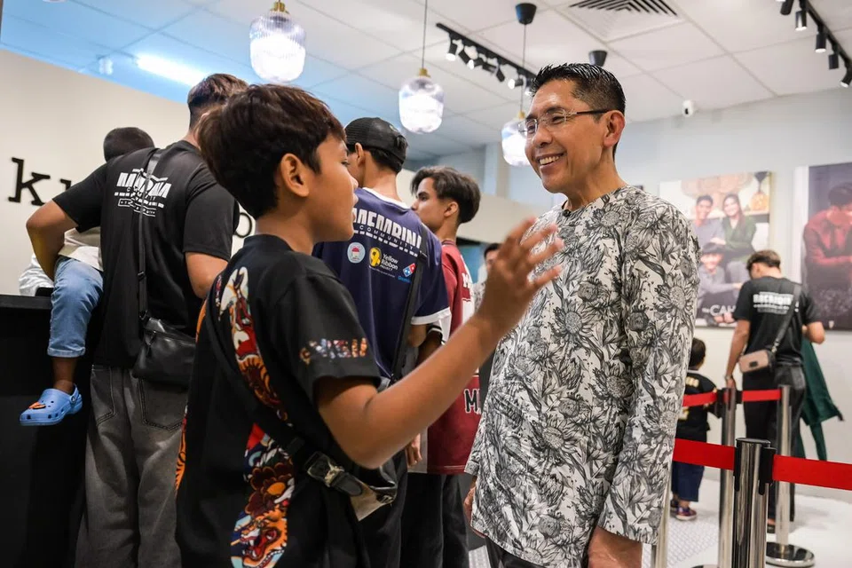Menteri di Pejabat Perdana Menteri dan Menteri Kedua (Pendidikan dan Ehwal Luar), Dr Maliki Osman sedang berinteraksi dengan seorang penerima di kedai Kurta Boys yang membeli baju raya.