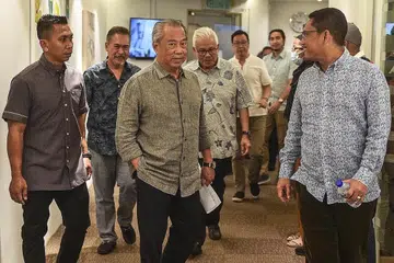TEMU MEDIA: Pengerusi Perikatan Nasional, Tan Sri Muhyiddin Yassin (tiga dari kiri) tiba untuk menghadiri sidang media di ibu pejabat parti itu di Kuala Lumpur, kelmarin. Turut bersamanya ialah Timbalan Presiden Bersatu, Datuk Seri Ahmad Faizal Azumu (kanan). - Foto AFP