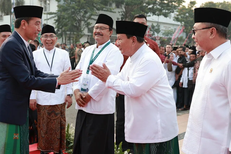 DAPAT RESTU: Presiden Indonesia, Encik Joko Widodo (kiri) bersalaman dengan calon presiden Encik Prabowo Subianto dalam majlis memperingati Hari Santri Nasional 2023 pada Ahad. 