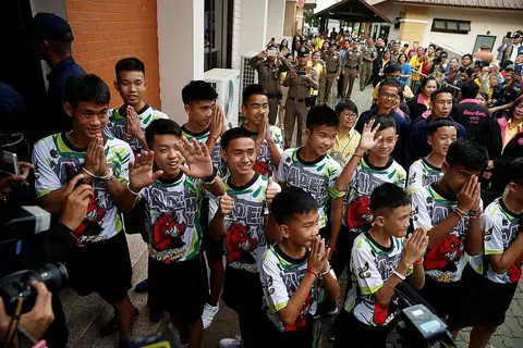 SUDAH SIHAT: Anggota pasukan bola sepak 'Wild Boars' tiba di lokasi sidang media di Chiang Rai semalam. - Foto REUTERS