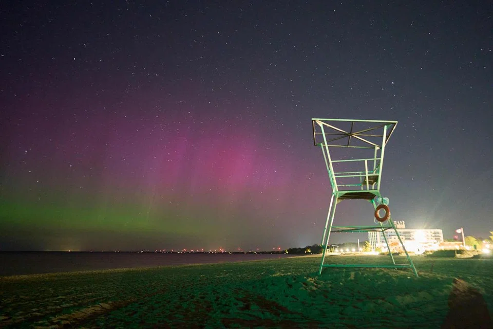 Cahaya aurora yang mempesona menerangi langit malam di pantai di Grand Bend, Ontario, Canada, pada 12 Mei.