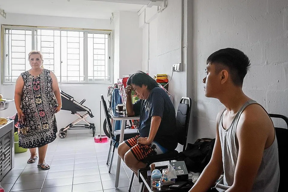 UCAP TAKZIAH: Encik Muhammad Azri Ramlan (kanan) dan mentuanya, Encik Jamari Yatno (tengah) dan Cik Yurni di rumah sementara mereka. Mereka adalah antara tujuh orang yang tinggal di flat terbakar kelmarin. - Foto BH oleh GAVIN FOO