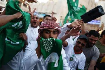 PENYOKONG RAIKAN KEMENANGAN: Peminat Arab Saudi meraikan kemenangan negaranya menentang Argentina di Souq Waqif di Doha, Qatar. - Foto REUTERS. 