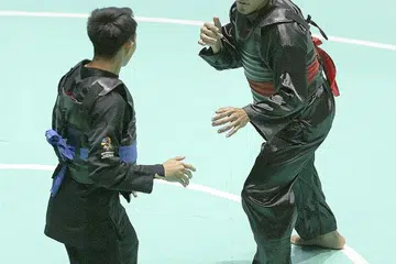 MUTU PENGADIL JADI TANDA TANYA: Shakir Juanda (kanan) semasa bertemu pesilat Indonesia Komang di suku akhir minggu lalu. Pertarungan itu berakhir dengan Shakir mengalami 'technical knock-out' selepas ditumbuk dimuka oleh lawannya. Tumbukan ke muka tidak dibenarkan dalam pertandingan silat.