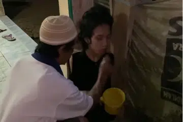 AMBIL WUDHU: Encik Wawan Satrio (kiri) membantu Encik Tiyo Satrio mengambil wudhu sebagai persiapan untuk solat jemaah.