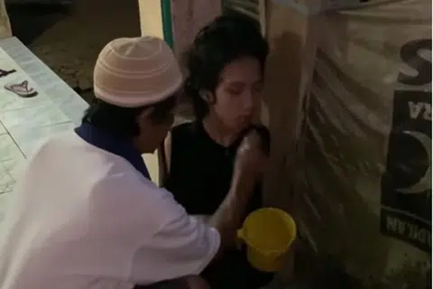 AMBIL WUDHU: Encik Wawan Satrio (kiri) membantu Encik Tiyo Satrio mengambil wudhu sebagai persiapan untuk solat jemaah.