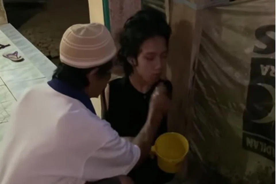 AMBIL WUDHU: Encik Wawan Satrio (kiri) membantu Encik Tiyo Satrio mengambil wudhu sebagai persiapan untuk solat jemaah.