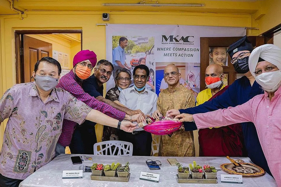 IFTAR PERERAT JALINAN: Encik Murali Pillai dan Encik Ameerali Abdeali (tiga dan enam dari kiri) serta wakil agama lain dan IRO di majlis iftar MKAC. Encik Murali turut menyampai habuan kepada penerima MKAC, termasuk Cik Siti Aminah Safari, yang mewakili suaminya. - Foto-foto BH oleh NUR DIYANA TAHA