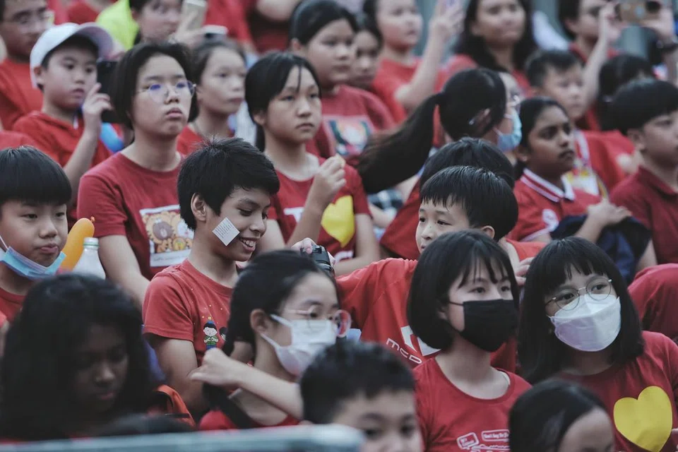 PENGALAMAN ISTIMEWA: Pelajar Sekolah Rendah Teck Ghee, Afham Syiddiqi kelihatan menampal pelekat tatu NDP di pipinya sementara temannya merakam perbuatan itu dengan telefon bimbit.
