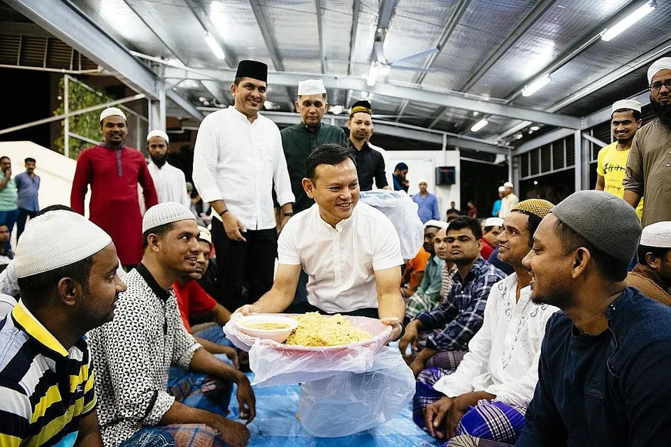 HIDANGAN SAHUR: Encik Zaqy membantu mengagihkan nasi beriani sebagai juadah bersahur kepada pekerja asing sewaktu lawatannya ke dormitori The Leo awal pagi semalam. - Foto BH oleh ALVIN HO