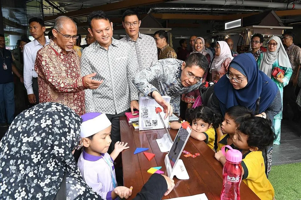 MAJLIS PELANCARAN: (Berdiri dari kiri), Encik Masagos Zulkifli Masagos Mohamad; Menteri Negara (Tenaga Manusia merangkap Pembangunan Negara), Encik Zaqy Mohamad; Ketua Eksekutif Muis, Encik Esa Masood dan Menteri Negara Kanan (Pertahanan merangkap Ehwal Luar), Dr Mohamad Maliki Osman berinteraksi dengan kanak-kanak prasekolah semalam. - Foto BH oleh KHALID BABA
