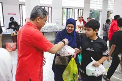 Encik Saktiandi (kiri) mengagih makanan kepada benefisiari di bawah inisiatif Pengedaran Bubur dan Juadah Bulan Ramadan Toa Payoh East di Kelab Masyarakat Toa Payoh Selatan pada 28 Februari.