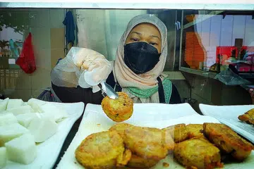 PERNIAGAAN BARU: Cik Marliya sedang menyediakan mi soto dari gerai barunya di Pusat Penjaja Old Airport Road dengan menggunakan francais mi soto popular Adam Road. Beliau menerima bimbingan daripada pemilik gerai mi soto popular di Adam Road, Encik Sumadi Sapari. - Foto BH oleh MOHD KHALID BABA