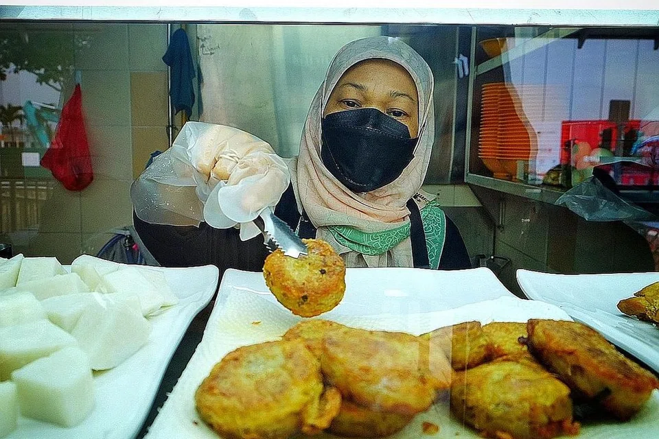 PERNIAGAAN BARU: Cik Marliya sedang menyediakan mi soto dari gerai barunya di Pusat Penjaja Old Airport Road dengan menggunakan francais mi soto popular Adam Road. Beliau menerima bimbingan daripada pemilik gerai mi soto popular di Adam Road, Encik Sumadi Sapari. - Foto BH oleh MOHD KHALID BABA