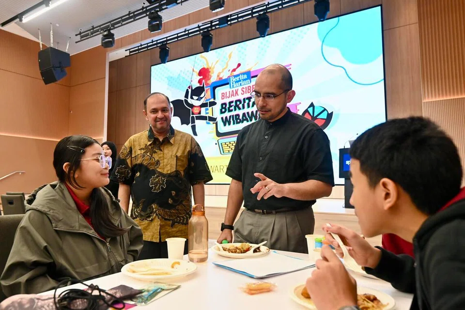 Timbalan Pengarah, Cawangan Bahasa Ibunda, Kementerian Pendidikan (MOE), Encik Zafilin Abdul Hamid (berdiri, kiri); dan Setiausaha Parlimen Kanan (Pendidikan merangkap Pembangunan Negara), Dr Syed Harun Alhabsyi (berdiri, kanan), berinteraksi dengan peserta Kem Wartawan Muda Gen G pada 4 Jun, di Auditorium SPH Media, di Toa Payoh North.