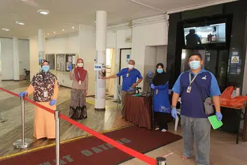 BARISAN HADAPAN BERKHIDMAT DI MASJID: Petugas dan sukarelawan Masjid Darul Makmur bersiap sedia untuk menerima kehadiran jemaah menunaikan solat Jumaat. - Foto MASJID DARUL MAKMUR