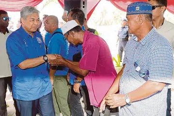 BN TERBUKTI BERUPAYA: Timbalan Perdana Menteri Malaysia, Datuk Seri Dr Ahmad Zahid Hamidi (kiri) menyambut peserta di sebuah acara di Kampung Banang, Hutan Melintang di Bagan Datuk pada 2 Mei lalu. - Foto NSTP