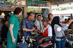 JADI TUMPUAN: Encik  George Goh, yang ditemani isterinya, Cik Lysa Sumali (baju hijau), beramah tamah bersama pesara Encik  Kamis Hassan, 75 tahun, di Pasar dan Pusat Makanan Haig Road pada Ahad.