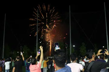 Pekerja migran Bangladesh dan India mengambil gambar bunga api semasa sambutan Tahun Baru di sebuah pusat rekreasi pekerja migran pada 1 Januari 2025.