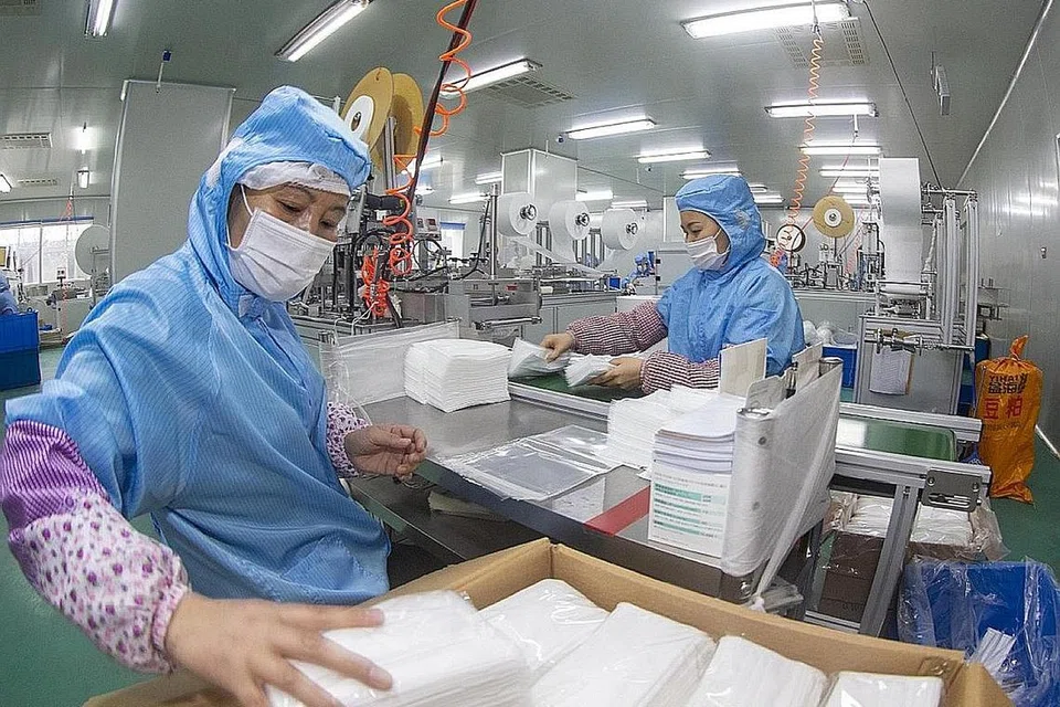 TINGKATKAN PENGELUARAN: Pekerja di sebuah kilang di Taizhou, wilayah Jiangsu, bekerja 24 jam bagi menghasilkan pelitup. - Foto CHINA DAILY