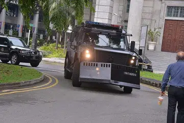 Tertuduh tiba untuk perbicaraan dalam konvoi yang dikawal ketat, termasuk kereta perisai polis. 