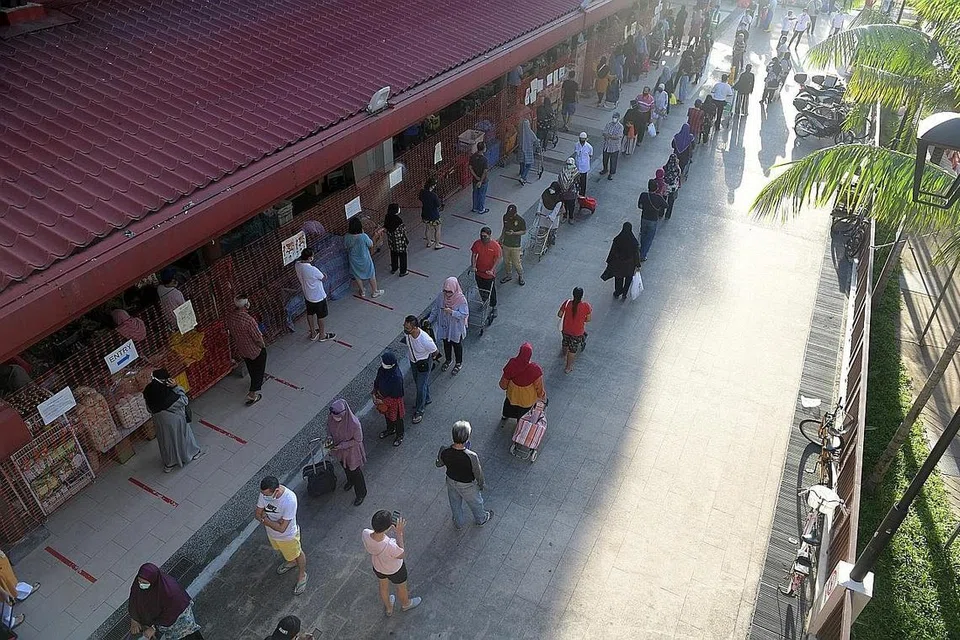 BARISAN PANJANG: Pengunjung perlu menunggu sekurang-kurangnya 30 minit sebelum dibenarkan memasuki Pasar Geylang Serai pada 7.30 pagi semalam, sedang masyarakat Melayu/Islam sibuk membuat persiapan Lebaran. - Foto BM oleh ALPHONSUS CHERN