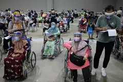 TUNGGU DAPATKAN VAKSIN: Golongan warga emas menantikan giliran untuk mendapatkan suntikan vaksin Covid-19 di pusat vaksinasi di Kuala Lumpur semalam. - Foto REUTERS