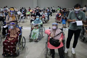 TUNGGU DAPATKAN VAKSIN: Golongan warga emas menantikan giliran untuk mendapatkan suntikan vaksin Covid-19 di pusat vaksinasi di Kuala Lumpur semalam. - Foto REUTERS