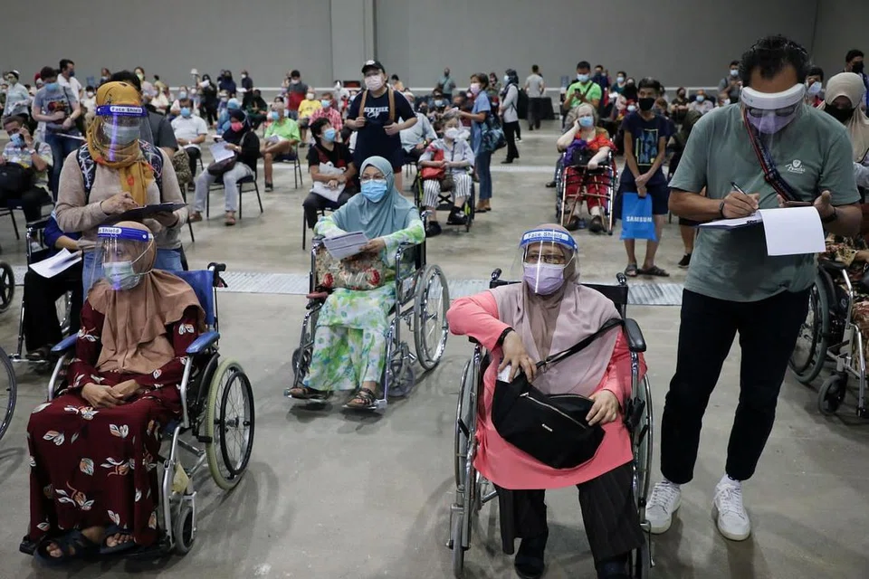 TUNGGU DAPATKAN VAKSIN: Golongan warga emas menantikan giliran untuk mendapatkan suntikan vaksin Covid-19 di pusat vaksinasi di Kuala Lumpur semalam. - Foto REUTERS