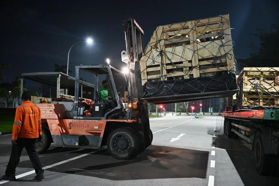 Kenderaan angkat susun, atau forklift, digunakan untuk mengangkat haiwan ternakan dalam palet masing-masing.