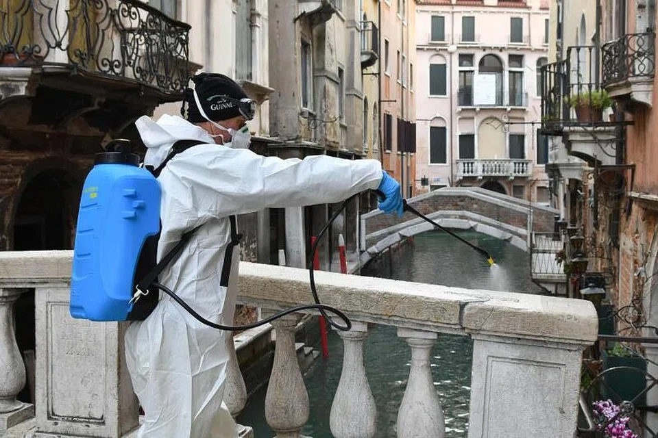 LANGKAH PENCEGAHAN: Seorang pekerja menyembur bahan penyahjangkit di Venice pada 11 Mac 2020 sebagai langkah pencegahan terhadap wabak koronavirus. 
