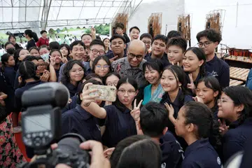 Presiden Tharman (berbaju batik) dan Cik Jane (berbaju biru) bersama pelajar daripada Sekolah Menengah Hougang selepas persembahan mereka sempena rumah terbuka di Istana pada 21 April.