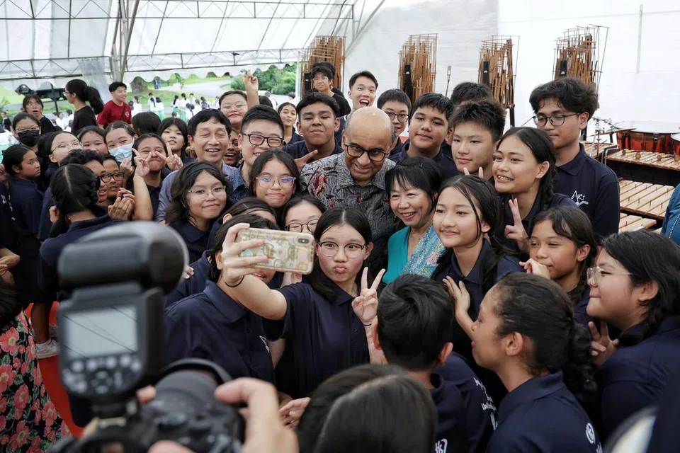 Presiden Tharman (berbaju batik) dan Cik Jane (berbaju biru) bersama pelajar daripada Sekolah Menengah Hougang selepas persembahan mereka sempena rumah terbuka di Istana pada 21 April.