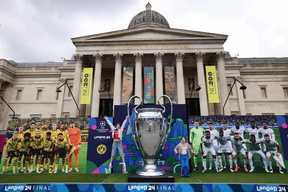 Penyokong dilihat bergambar dengan replika trofi Liga Juara-Juara di Festival Champions di Trafalgar Square, London, pada 30 Mei 2024. 