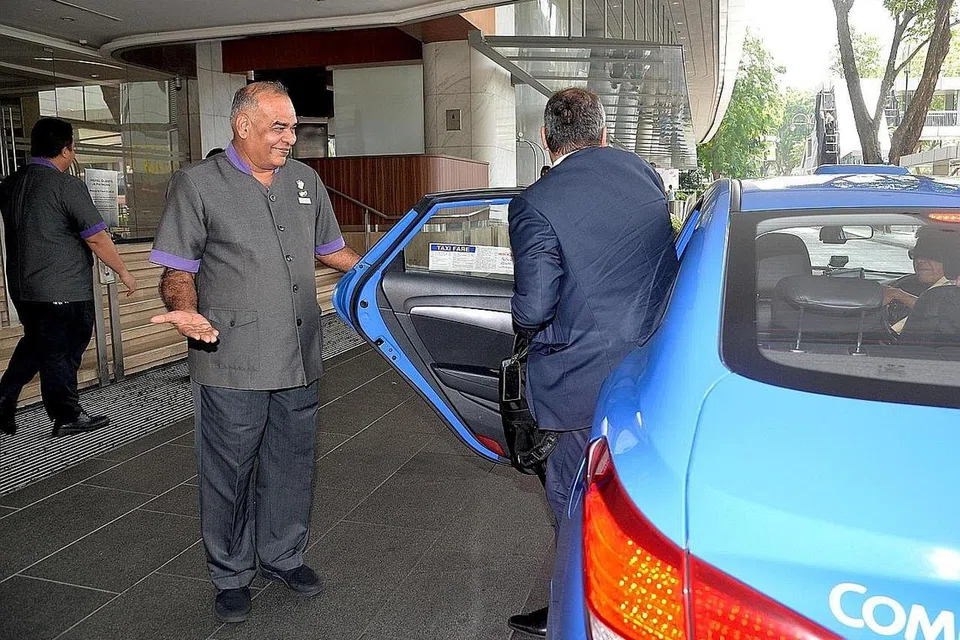 SETIA BERTUGAS: Syed Kadir masih menunjukkan keceriaan setiap kali menyambut tetamu Royal Plaza on Scotts, walaupun sudah 40 tahun berkhidmat. - Foto M.O. SALLEH