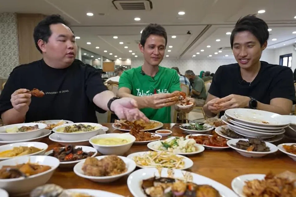 Dengan lebih 9.25 juta pengikut di YouTube, Mark Wiens (tengah) merupakan antara 'vlogger' makanan dan pelancongan yang popular di dunia. - Foto YOUTUBE MARK WIENS