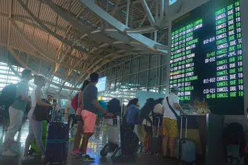 TERJEJAS: Penumpang beratur di kaunter Lapangan Terbang Antarabangsa Ngurah Rai semalam setelah beberapa penerbangan dibatalkan ekoran letusan Gunung Agung. - Foto ANTARA FOTO