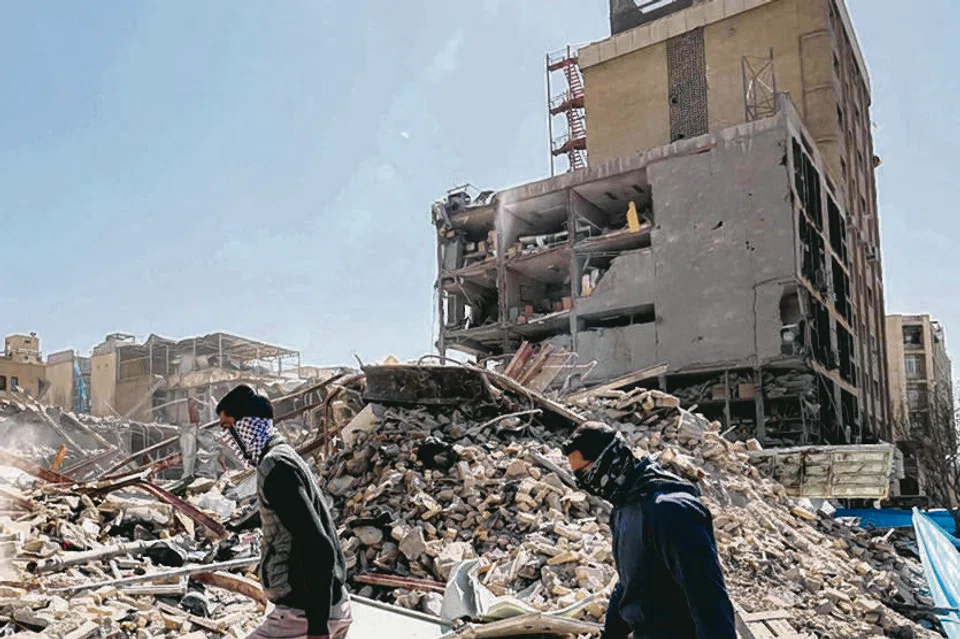 Beberapa individu memeriksa runtuhan sebuah bangunan yang runtuh berhampiran Dataran Ferdowsi di Teheran pada 3 Mac 2026. Amerika Syarikat dan Israel mula melancarkan serangan ke atas Iran pada 28 Februari, yang mengorbankan pemimpin tertinggi Iran serta beberapa pemimpin tentera kanan, sekali gus mencetuskan serangan balas Iran terhadap Israel dan beberapa sasaran di negara Teluk.