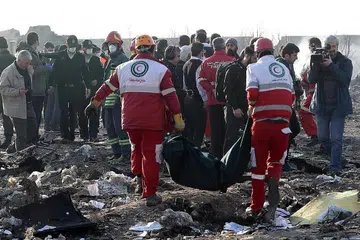 TAPAK TRAGEDI: Anggota Bulan Sabit Merah Antarabangsa membawa mayat dari tapak nahas pesawat Ukraine International Airlines Boeing 737-800 yang terhempas berdekatan Lapangan Terbang Imam Khomeini di Teheran, sekali gus membunuh kesemua 176 orang di dalamnya. - Foto EPA-EFE