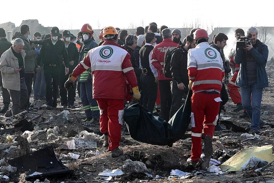 TAPAK TRAGEDI: Anggota Bulan Sabit Merah Antarabangsa membawa mayat dari tapak nahas pesawat Ukraine International Airlines Boeing 737-800 yang terhempas berdekatan Lapangan Terbang Imam Khomeini di Teheran, sekali gus membunuh kesemua 176 orang di dalamnya. - Foto EPA-EFE