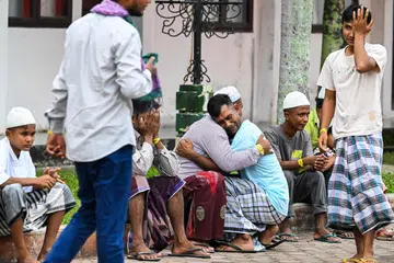 Pelarian Rohingya saling berpelukan selepas solat sunat Aidilfitri  di pusat perlindungan sementara di Meulaboh, wilayah Aceh, Indonesia pada 10 April.