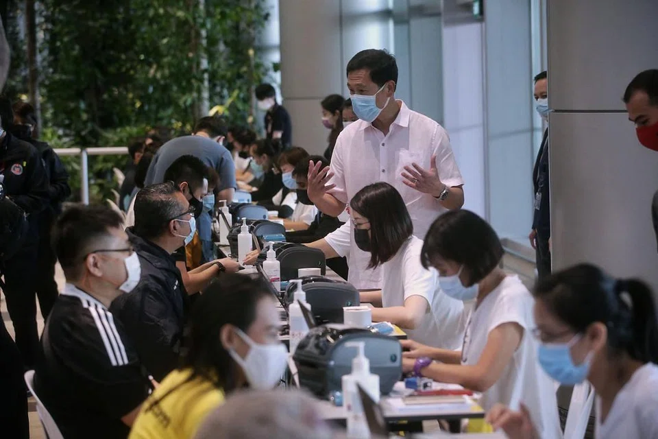 VAKSIN COVID-19: Encik Ong (berdiri) bercakap dengan pekerja yang hadir mendapatkan dos pertama vaksin Covid-19 di Terminal 4 Lapangan Terbang Changi semalam. Encik Ong turut mendapatkan dos pertama vaksin Covid-19. - Foto BH oleh KEVIN LIM 