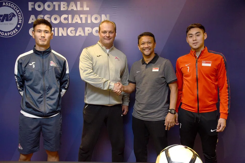 PERLAWANAN PERSAHABATAN: Jurulatih skuad negara Fandi Ahmad (dua dari kanan) berjabat tangan dengan jurulatih Mongolia, Michael Weiss. Bersama mereka di sidang media semalam termasuk pemain Mongolia Daginaa Turbat (kiri) dan pemain negara Gabriel Quek (kanan). - Foto FAS