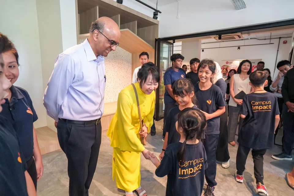 Puan Jane Ittogi (berbaju kuning) bersalaman dengan salah seorang kanak-kanak yang disokong oleh CampusImpact pada pelancaran Cabaran Presiden 2024 sambil diperhatikan Presiden Tharman Shanmugaratnam (kiri), Nur Qamarina Muhammad Rhyme (tiga dari kanan) dan Nur Syarafina Muhammad Rhyme (dua dari kanan).