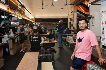 'PENGIKTIRAFAN HEBAT': Jika budaya penjaja diterima dalam senarai Unesco, penjaja seperti pemilik gerai Nasi Lemak Ayam Taliwang, Encik Mohammed Noorman Mubarak Ahmad (kanan), menyifatkannya sebagai satu pengiktirafan besar bagi golongan peniaga sepertinya. - Foto BH oleh KHALID BABA