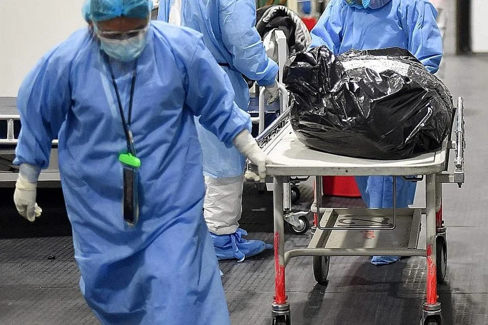 KORBAN COVID-19: Kakitangan perubatan memindahkan mayat Covid-19 di Hospital Honorio Delgado di Arequipa, Peru. - Foto AFP