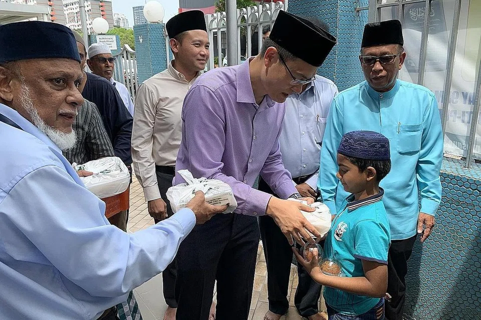 BERSAMA MASYARAKAT: Encik Esa (baju ungu) membantu mengagihkan nasi beriani kepada jemaah masjid selepas solat Jumaat di Masjid Malabar pada November 2019. - Foto fail