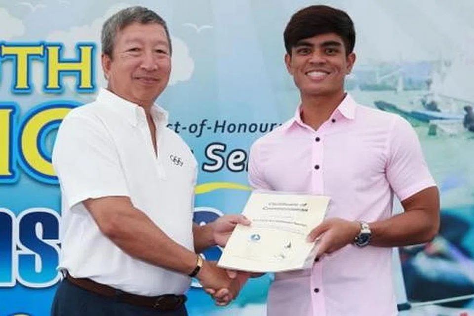 TERIMA SIJIL: Encik Nur Hafiz (kanan) menerima sijil penghargaan daripada Anggota Jawatankuasa Olimpik dan Pengerusi Jawatankuasa Pemasaran Majlis Olimpik Kebangsaan Singapura (SNOC), Encik Ng Ser Miang, kerana terlibat secara sukarela dalam penganjuran kejuaraan papan luncur angin terbuka Asia SIM Singapura tahun lalu. - Foto KELAB PELAYARAN SINGAPURA
